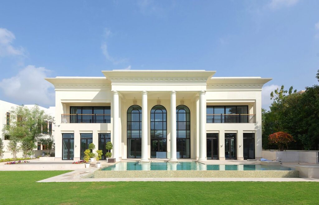 A large white villa with columns and a pool in Emirates Hills